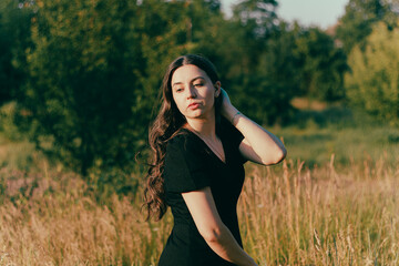 Naklejka na ściany i meble girl with long hair.woman's mental health.calm peaceful dreamy girl.woman dreams and thinks.feeling of relaxation.self-confidence. Sad woman.cheerful woman outdoors.relaxed girl. walking in the meadow