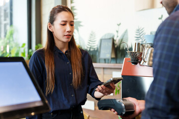 attractive asian woman Use banking applications via smartphones. Present your credit card to Indian restaurant owner to pay for food and beverages. Touch the electronic cash register. Pay without cash