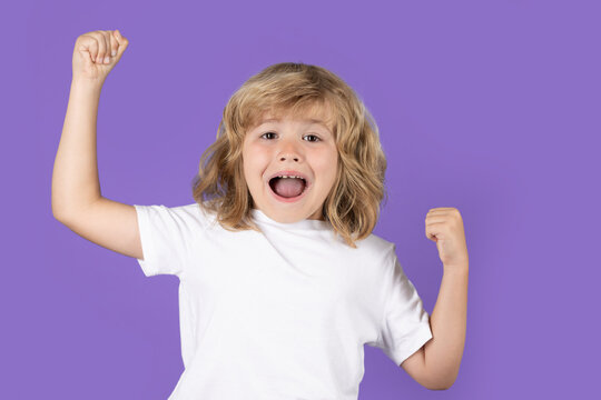 Excited kid boy celebrating victory on studio isolated background. Surprised kids face, amazed emotions of child. Rejoicing, yes gesture and success concept.