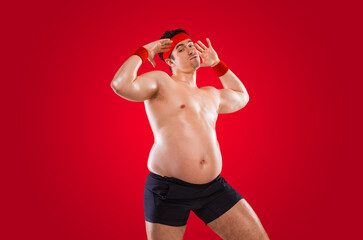 A funny fat man isolated on red background. Obesity and eating disorder. Concept for dietetics and...