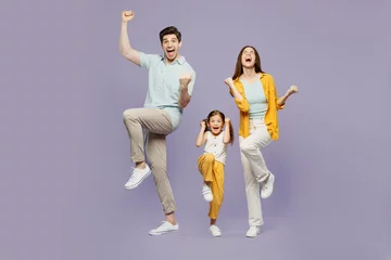 Abwaschbare Fototapete Alte Türen Full body young parent mom dad with child kid daughter girl 6 years old wear blue yellow casual clothes do winner gesture celebrate raise up leg isolated on plain purple background Family day concept