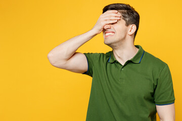 Fototapeta na wymiar Young sad mistaken caucasian man he wears green t-shirt casual clothes put hand on face facepalm epic fail mistaken omg gesture isolated on plain yellow background studio portrait. Lifestyle concept.