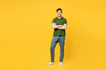 Fototapeta na wymiar Full body young smiling cheerful satisfied happy man he wears green t-shirt casual clothes look camera hold hands crossed folded isolated on plain yellow background studio portrait. Lifestyle concept.
