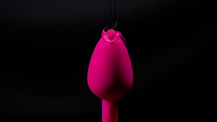 Pink anal plug in intimate lubricant on a black background. Copy space.  - obrazy, fototapety, plakaty