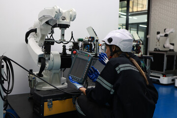 Caucasian two young female engineers learning robotic arm in training class together, innovation and development smart 4.0 factory concept.