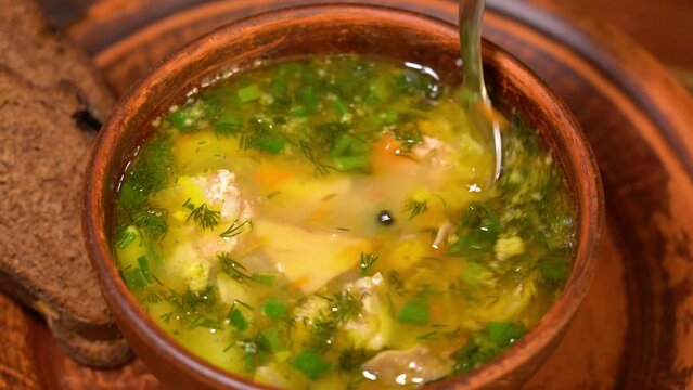 Pouring polish traditional soup called zur or white borscht.