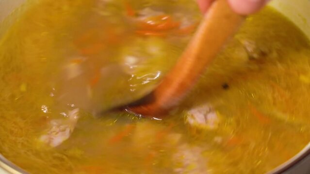 Pouring polish traditional soup called zur or white borscht.
