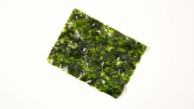 Dried seaweed chips wakame. Japanese kelp snack. Dry Green Edible seaweed Undaria pinnatifida. Convenient semifinished product, processed food. 4K Video, Rotating.
