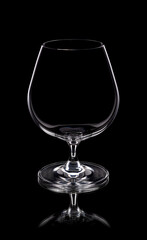 An empty glass of brandy on black background