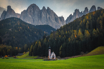 Autumn alpine scenery and small church on the green fields