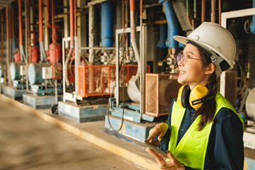 Side view Smiling smart asian female technician in engineering department wearing safety helmet and...
