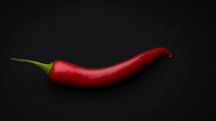 one chilli on black.table background