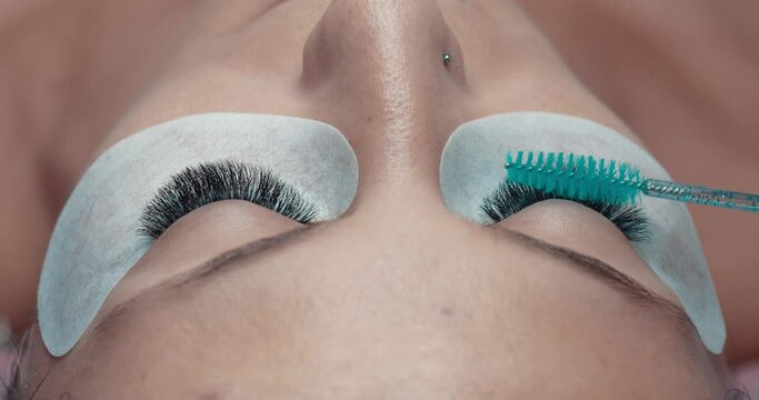 Eyelash extension test with brush on female model. Checking procedure for lashes , close up