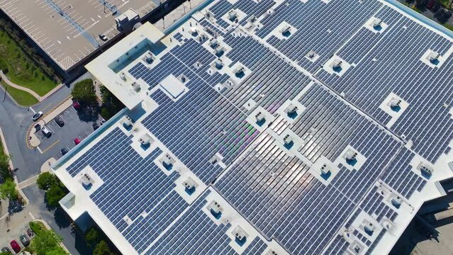 Aerial view of many photovoltaic panels installed on shopping mall roof top for producing of green ecological electricity. Production of sustainable energy concept