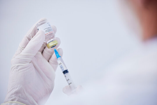 Vaccine bottle, needle and hands of doctor for safety, healthcare and pharmaceutical medicine. Closeup, virus injection and nurse prepare vaccination with vial, medical drugs and immunity in clinic