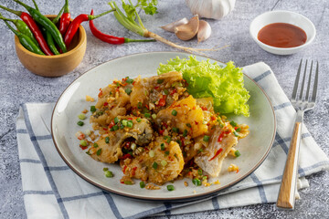Fried sea bass with salt and pepper on the table