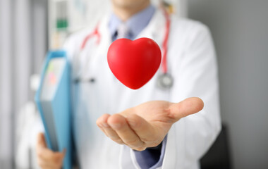 Doctor catches heart while holding folders hands. High blood pressure. Prevention cardiovascular...