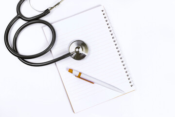 Doctor desk.Stethoscope notebook and pen on white background