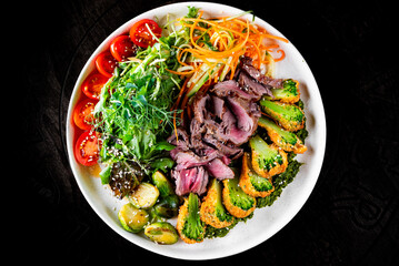 Roast beef salad with vegetables on plate