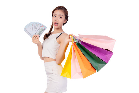 Excited beautiful woman hold shopping bags and money isolated on white background and copy space Surprise happy asian young lady open mouth with surprise Beauty young cheerful female get money back