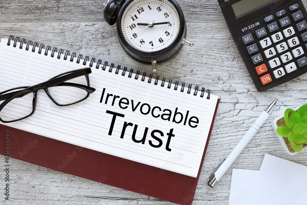Poster irrevocable trust business concept top view of diary and desk clock. text on paper