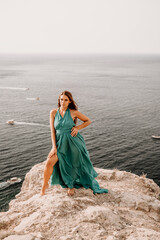 Fototapeta na wymiar Woman sea green dress. Side view a happy woman with long hair in a long mint dress posing on a beach with calm sea bokeh lights on sunny day. Girl on the nature on blue sky background.