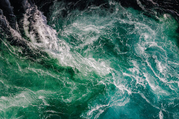 Blue waves of water of the river and the sea meet each other during high tide and low tide.