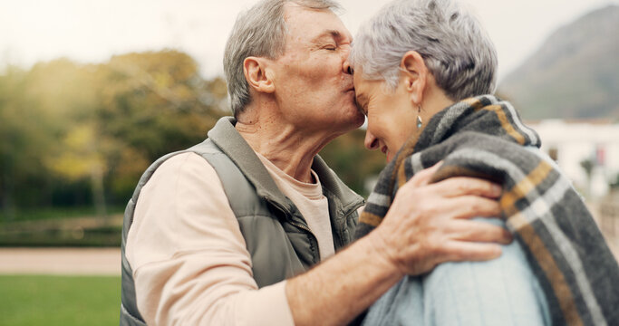 Forehead, kiss and senior couple in a park with love, happy and conversation with romantic bonding. Kissing, old people and elderly man embrace woman with care, romance or soulmate connection outdoor