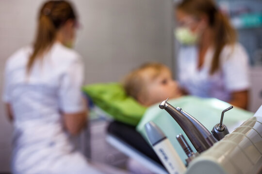 Medical equipment at dental office backdrop, patient child visits dentist doctor in medical clinic. Kid girl treats teeth, selective focus. Medicine children dentistry concept. Copy ad text space