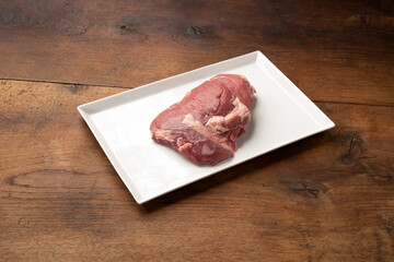 Frische rohe Damwild Keule Braten auf Porzellan und Eichen Brett 