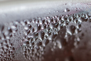Condensation as drops on metal plate under side light