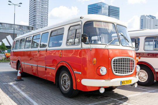 The old red and blue Skoda bus. Czechoslovakian Skoda RTO 706 Karosa model. Tourist buses vintage model. The street of the old city is a tourist attraction. Poland, Warsaw - July 27, 2023.