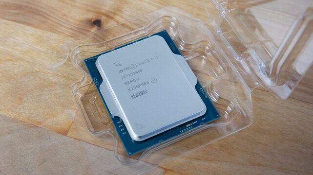 Intel Core i3-13100f Raptor Lake computer processor CPU on a brown wooden table.