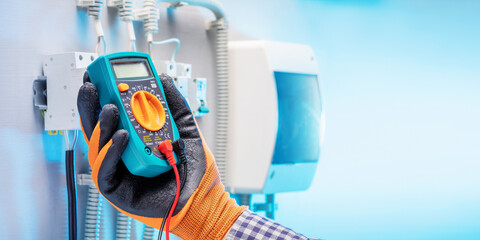 electrician work tester measuring voltage in fuse board. electrical engineering concept. banner...
