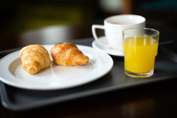 Continental breakfast coffee milk orange juice and croissant