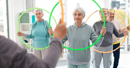 Fitness, senior and people with hula hoop at the gym for training, workout and health in retirement. Happy, together and a group of elderly friends with a coach and gear for an exercise class © Felix/peopleimages.com
