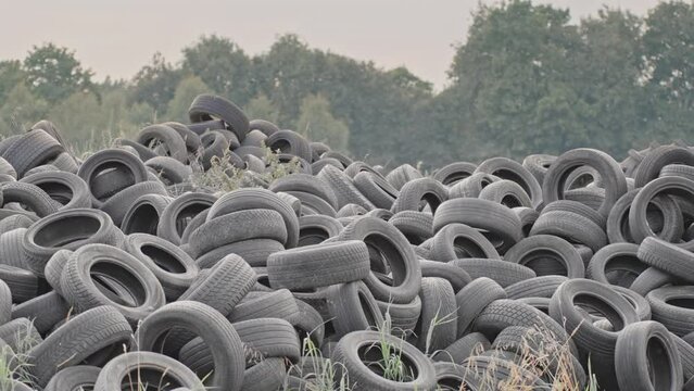car tires piled in a heap, wheel dump, landfill with old discarded tires, worn out car rubber for recycling