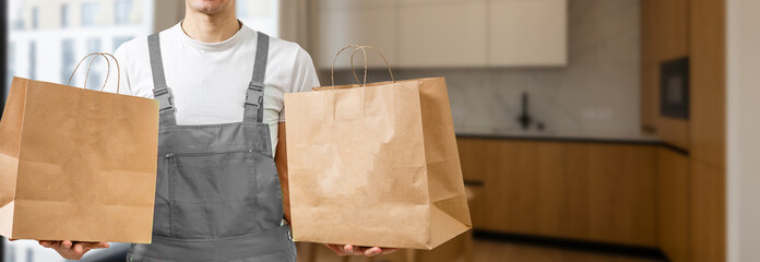 Diverse of paper containers for takeaway food. Delivery man is carrying pizza