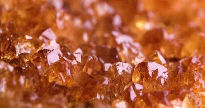 heated amethyst (citrine) crystal rotating light 4k. macro detail texture background. close-up raw rough unpolished semi-precious gemstone
