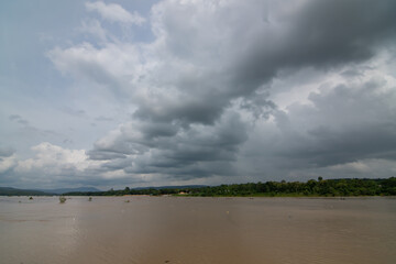 Dark clouds and rainstorm over the river rainy season in thailand