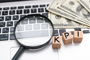 KPI ( Key Performance Indicator) - acronym on wooden cubes on the background of a cactus and...