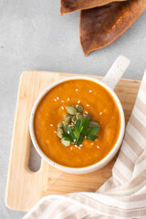 A mug of warm pumpkin soup. The concept of the autumn menu. Autumn recipes.