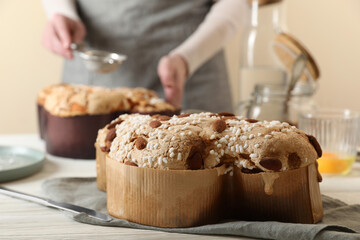 Delicious Italian Easter dove cake (traditional Colomba di Pasqua) on white wooden table, space for text