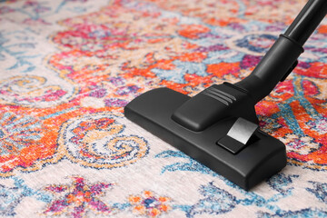 Hoovering carpet with modern vacuum cleaner, closeup