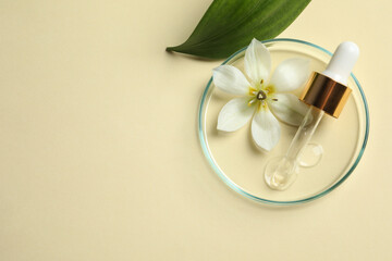 Petri dish with sample of cosmetic oil, pipette, beautiful flower and leaf on beige background, flat lay. Space for text