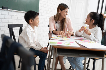 Teacher woman teaching children with paper and blackboard in class room