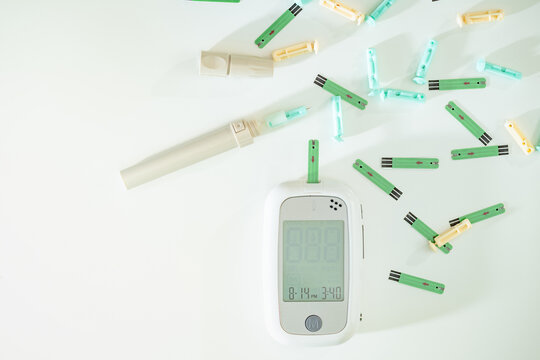 Top view the lancing device and blood lancets test needle and testing stripe and glucose meter for checking blood sugar level, Gestational diabetes and pregnancy health.