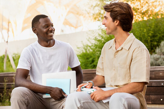 Happy guys chilling on street after school, have conversation
