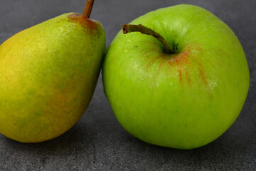 green apple and yellow pear on the table