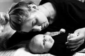 Infant small child with young mom. Pretty woman witn newborn baby.
